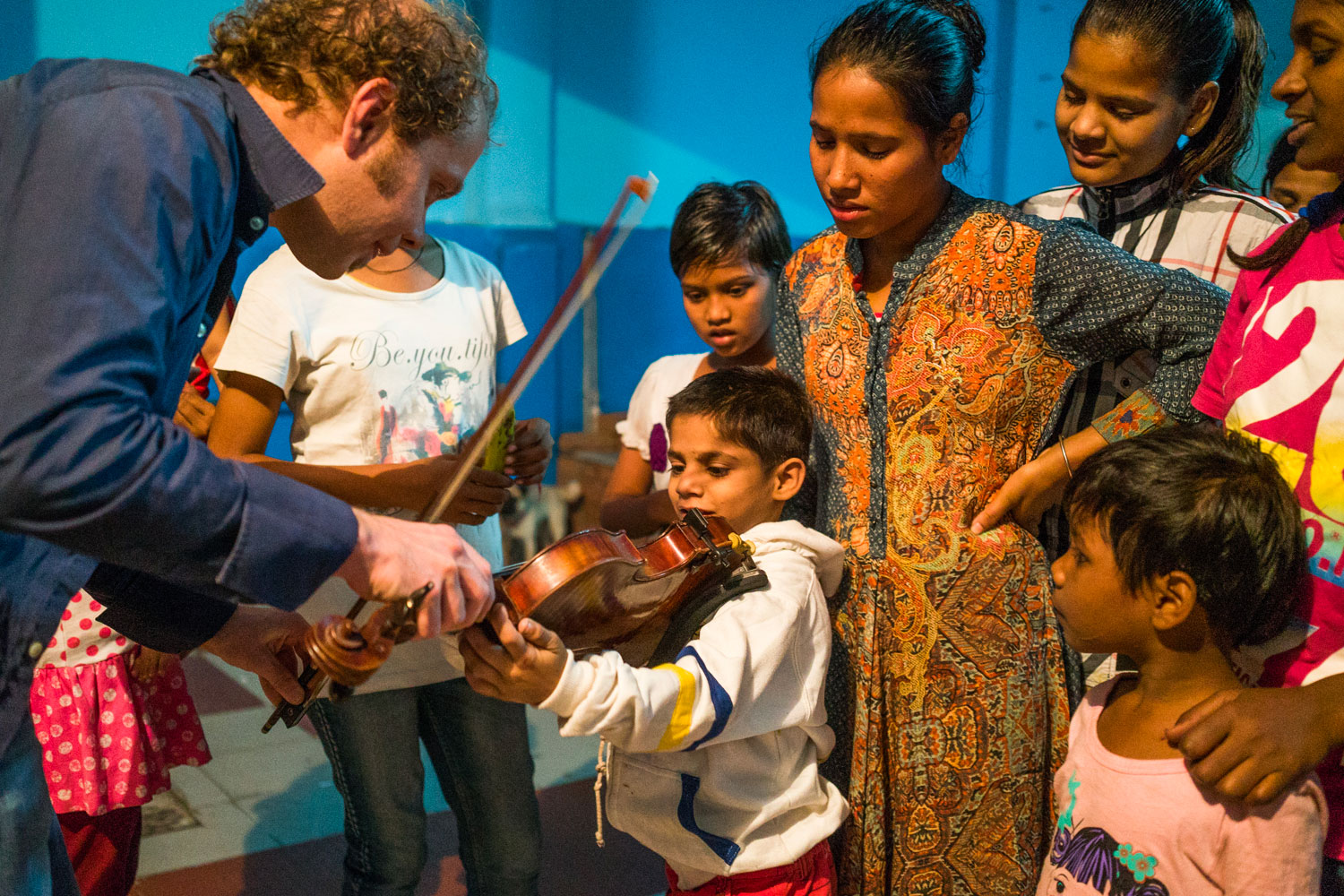 Pierre Droual faisant découvrir le violon à un enfant dans le cadre du projet Lyra